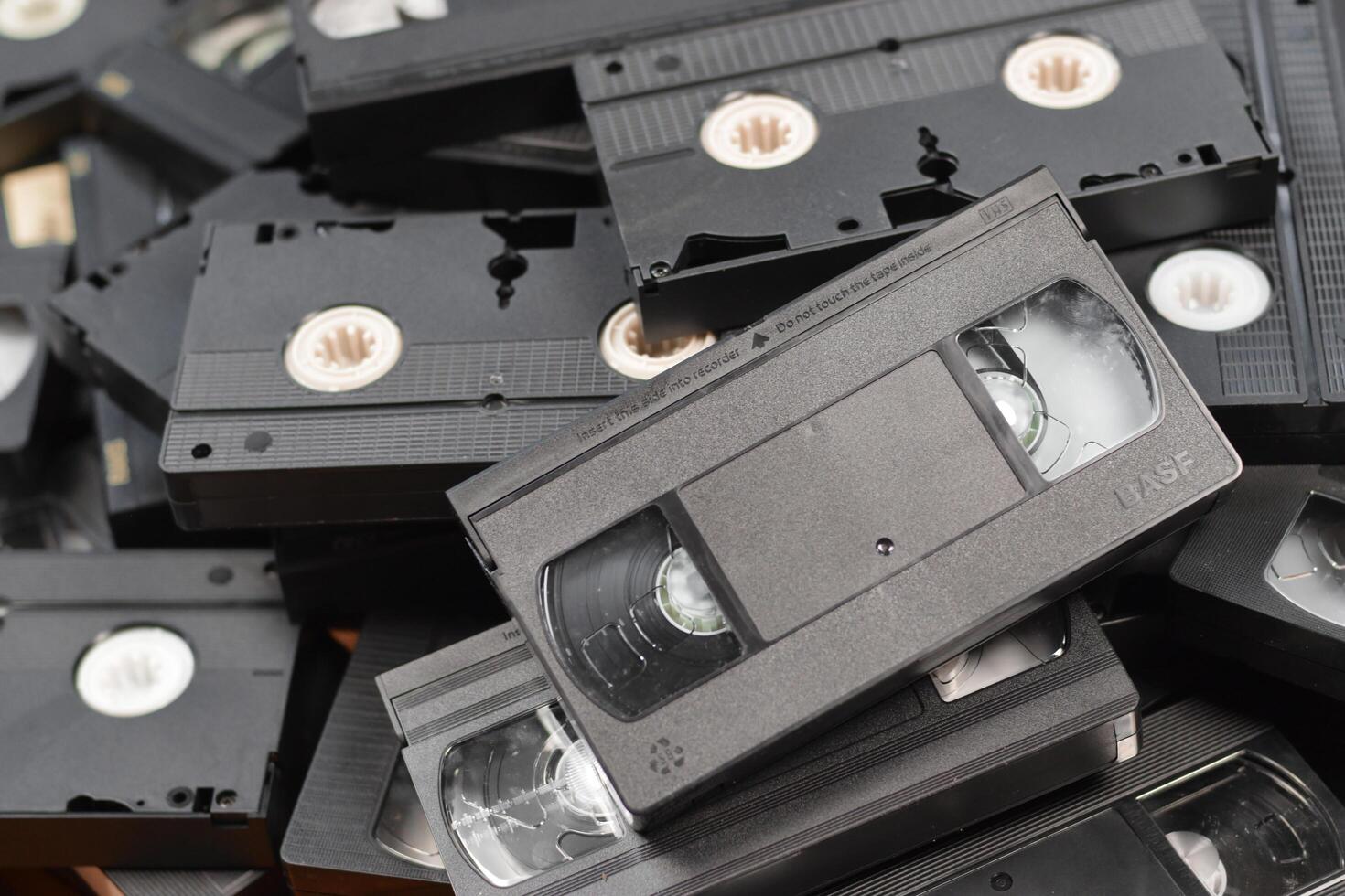 KYIV, UKRAINE - 4 MAY, 2023 tape on colored background, VHS, cassette. Messy stack of VHS tapes. Home System tape photo