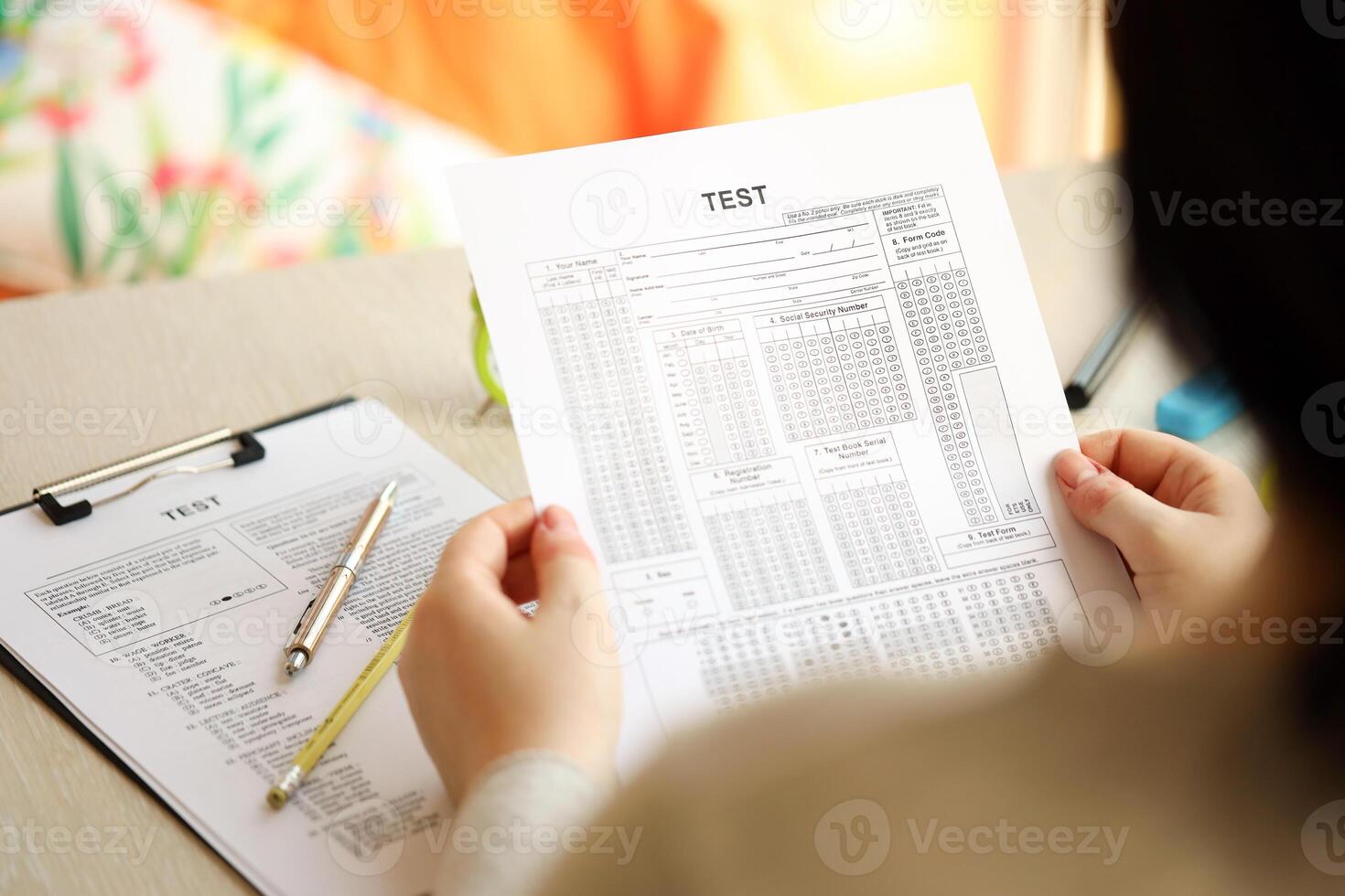 Female student hands testing in exercise and hold exam paper sheet with pencil at school test room photo
