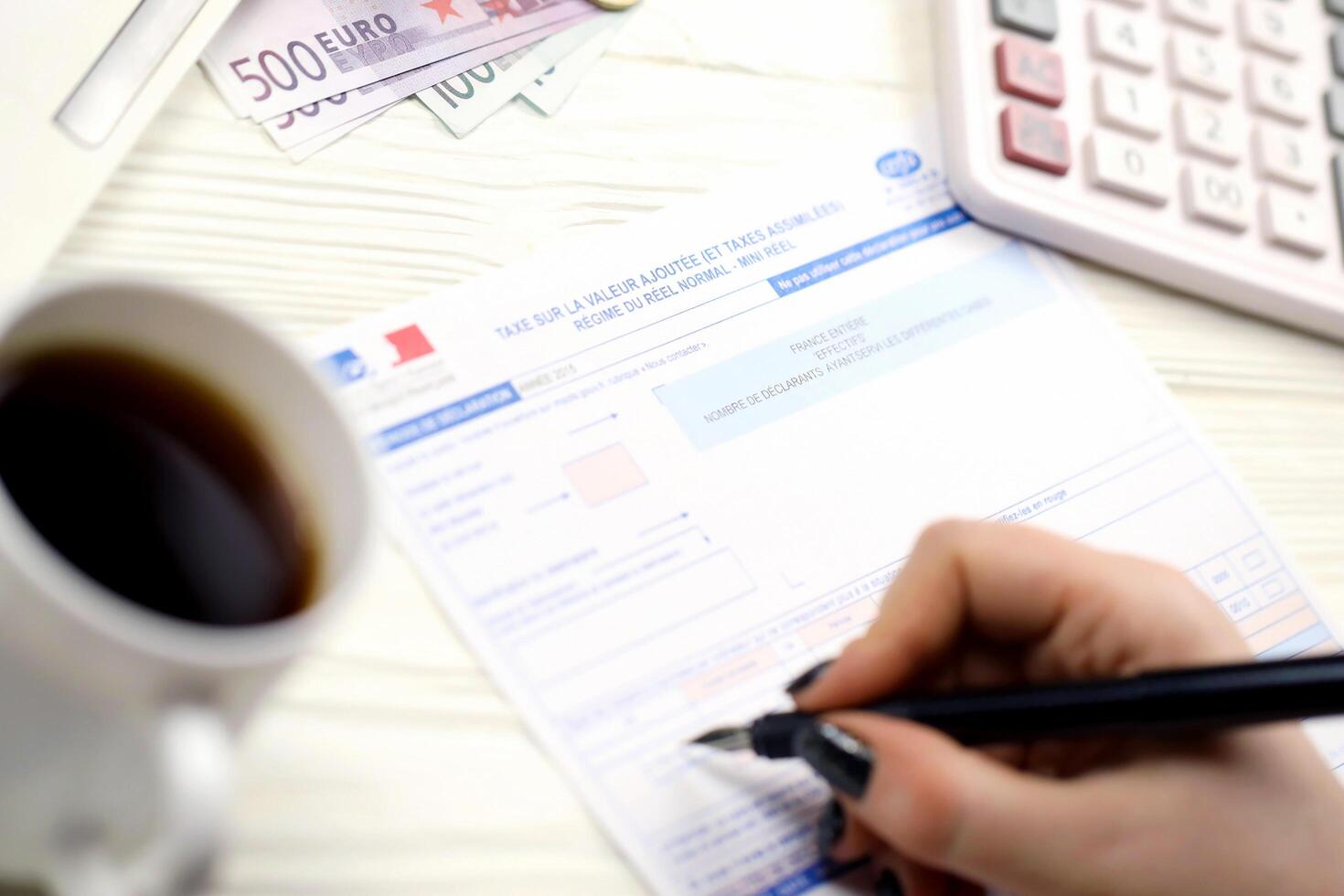 KYIV, UKRAINE - OCTOBER 31, 2023 Accountant fill french tax form 10963 Value added tax and similar taxes in end of tax period. Taxation and paperwork routine photo