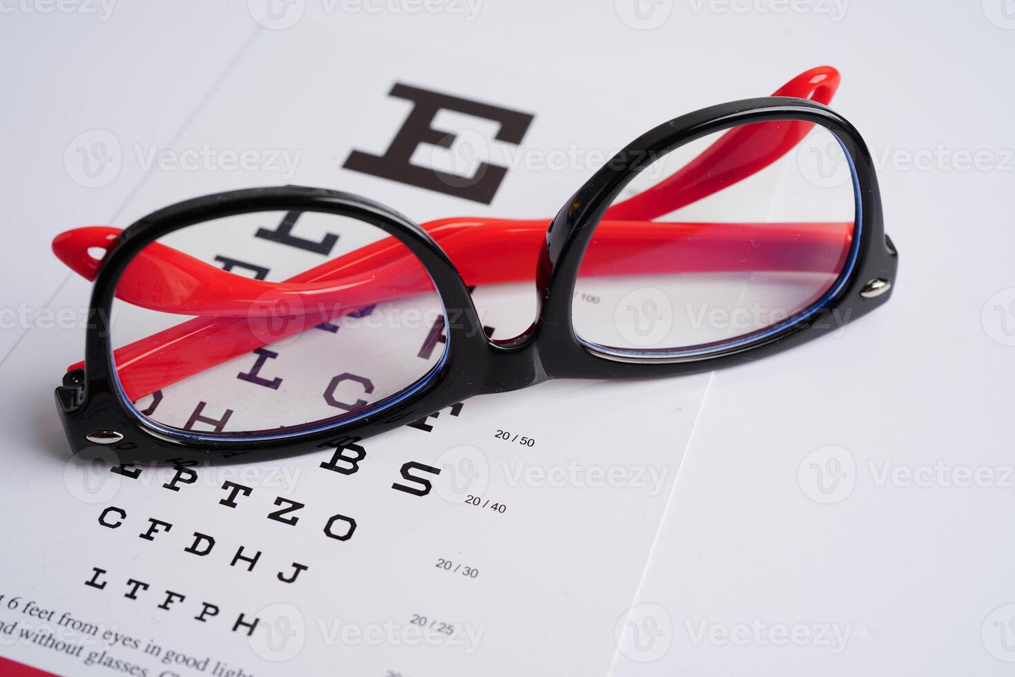 Glasses on eye exam chart to test eyesight accuracy of reading. photo