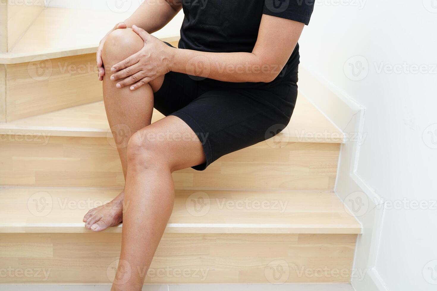 Asian lady woman injuries from falling down on slippery surfaces stairs in living room at home. photo