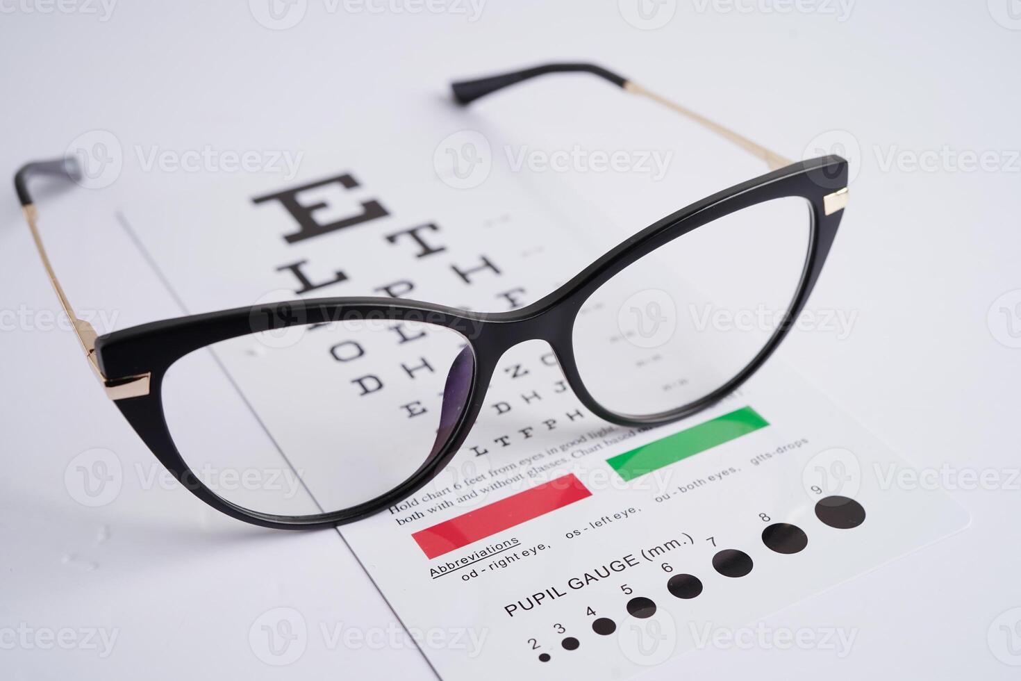 Glasses on eye exam chart to test eyesight accuracy of reading. photo
