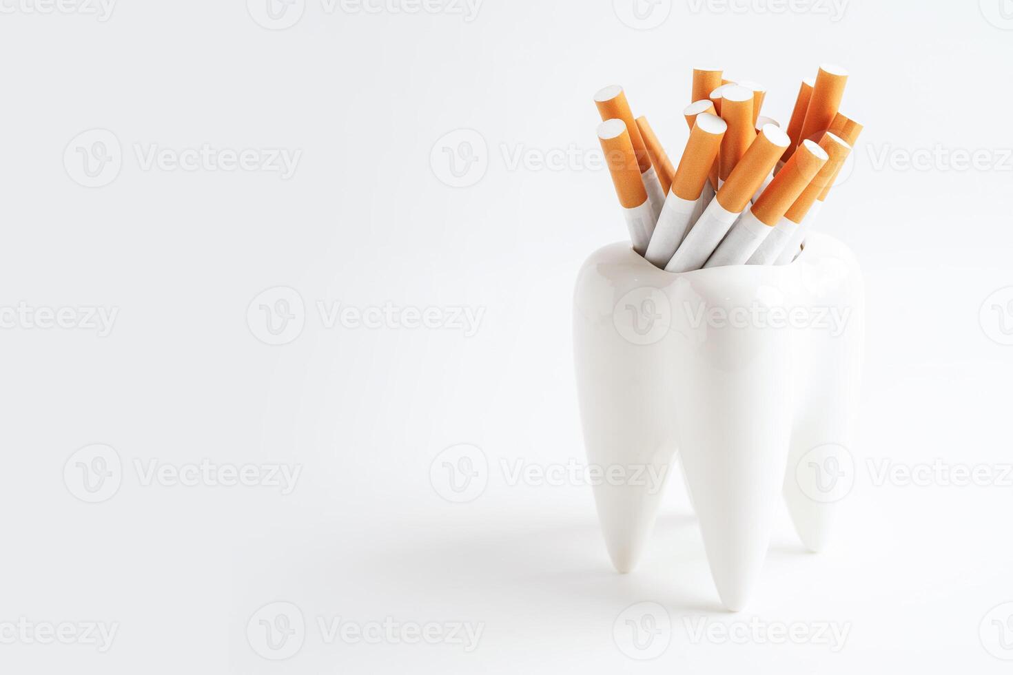 Cigarette with teeth isolated on white background with copy space, No smoking, damage the health of your teeth. photo