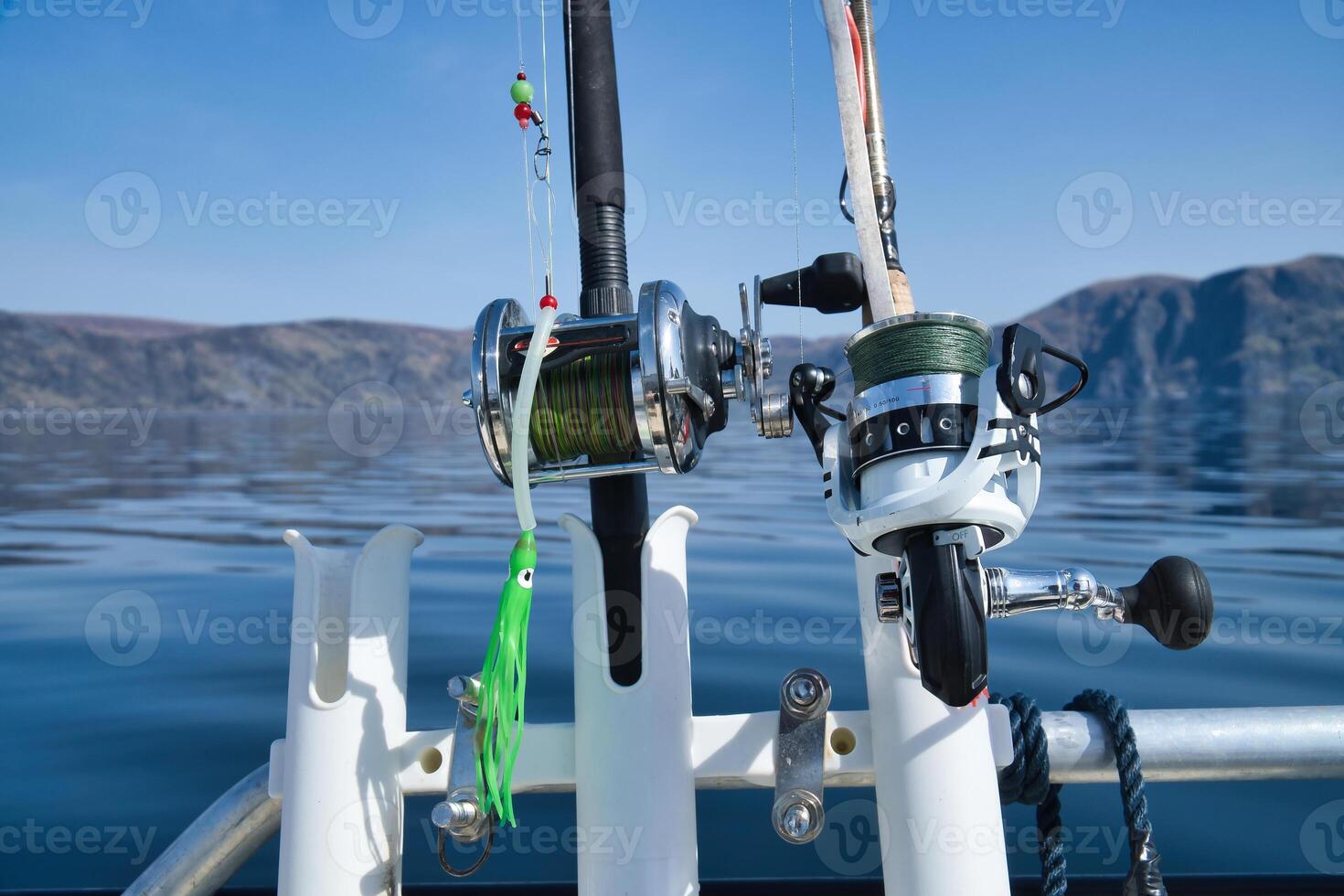 Fishing boat with fishing rod and reels off mountains in the Norwegian fjord landscape photo