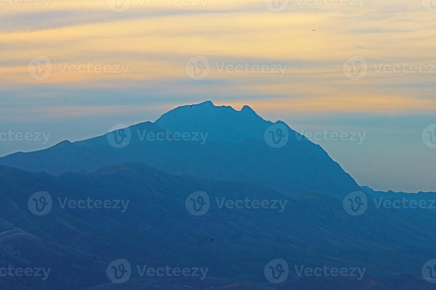 mountain peak in the shape of human face looking up at the sky in northern iraq with cloudy sky photo