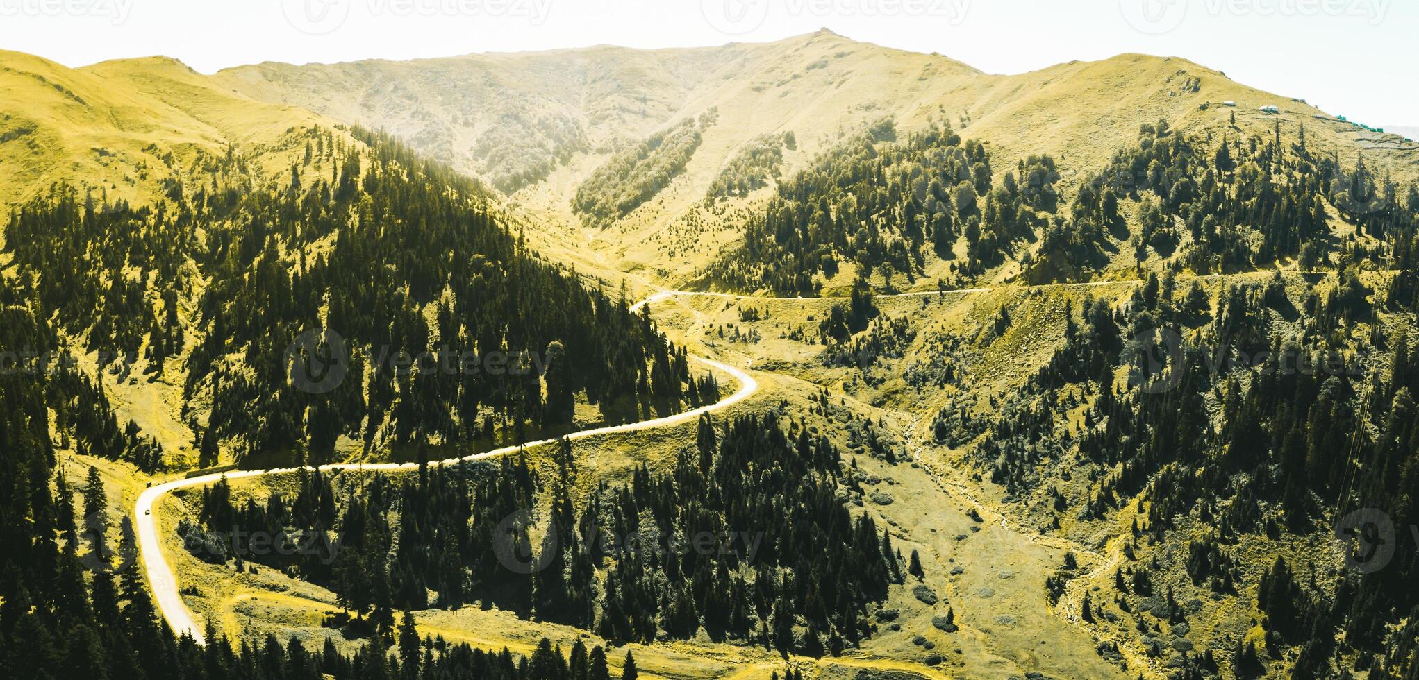 Aerial view vehicles drive travels in beautiful mountainous terrain. One car driving on an asphalt road with beautiful landscape of Georgia photo