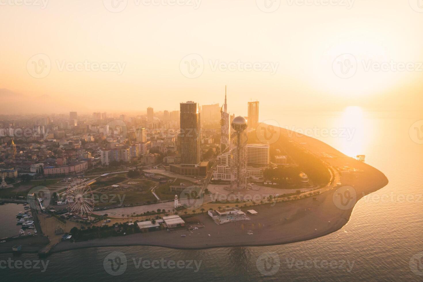 Iveria beach waterfront view with famous Batumi landmarks in the background - Chacha tower, Ferris wheel and alphabetic tower. Romantic holidays in Georgian vegas concept. photo