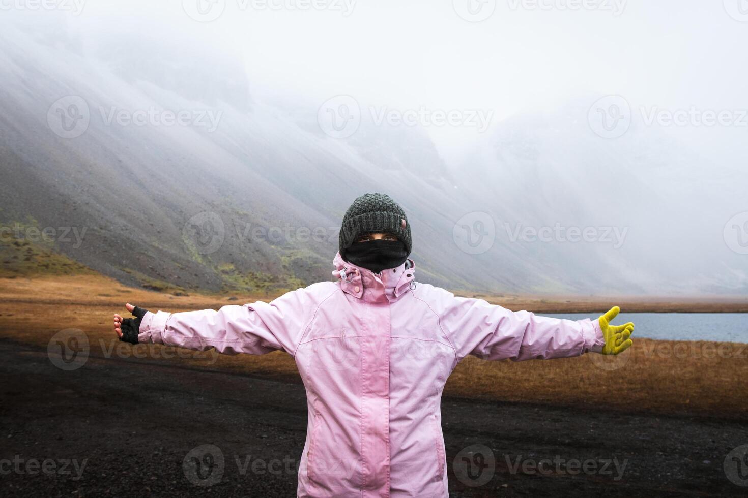 Close up caucasian woman wear gloves and warm clothes stand look at camera. Visit Iceland tourist attractions in harsh icelandic weather conditions photo