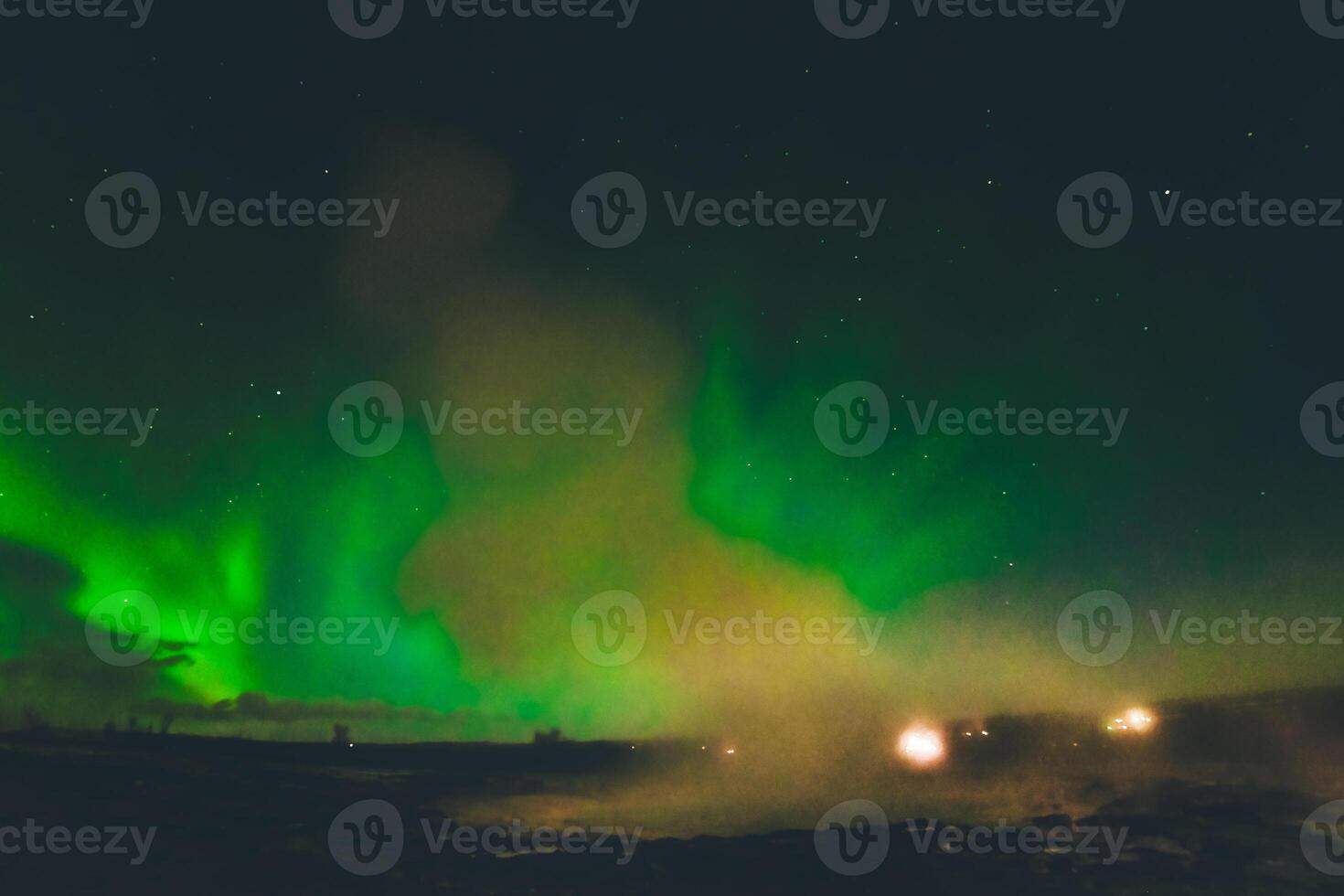 Beautiful aurora borealis over Geysir hot springs landmark in Iceland with eruptions. Travel sightseeing destination in Iceland photo