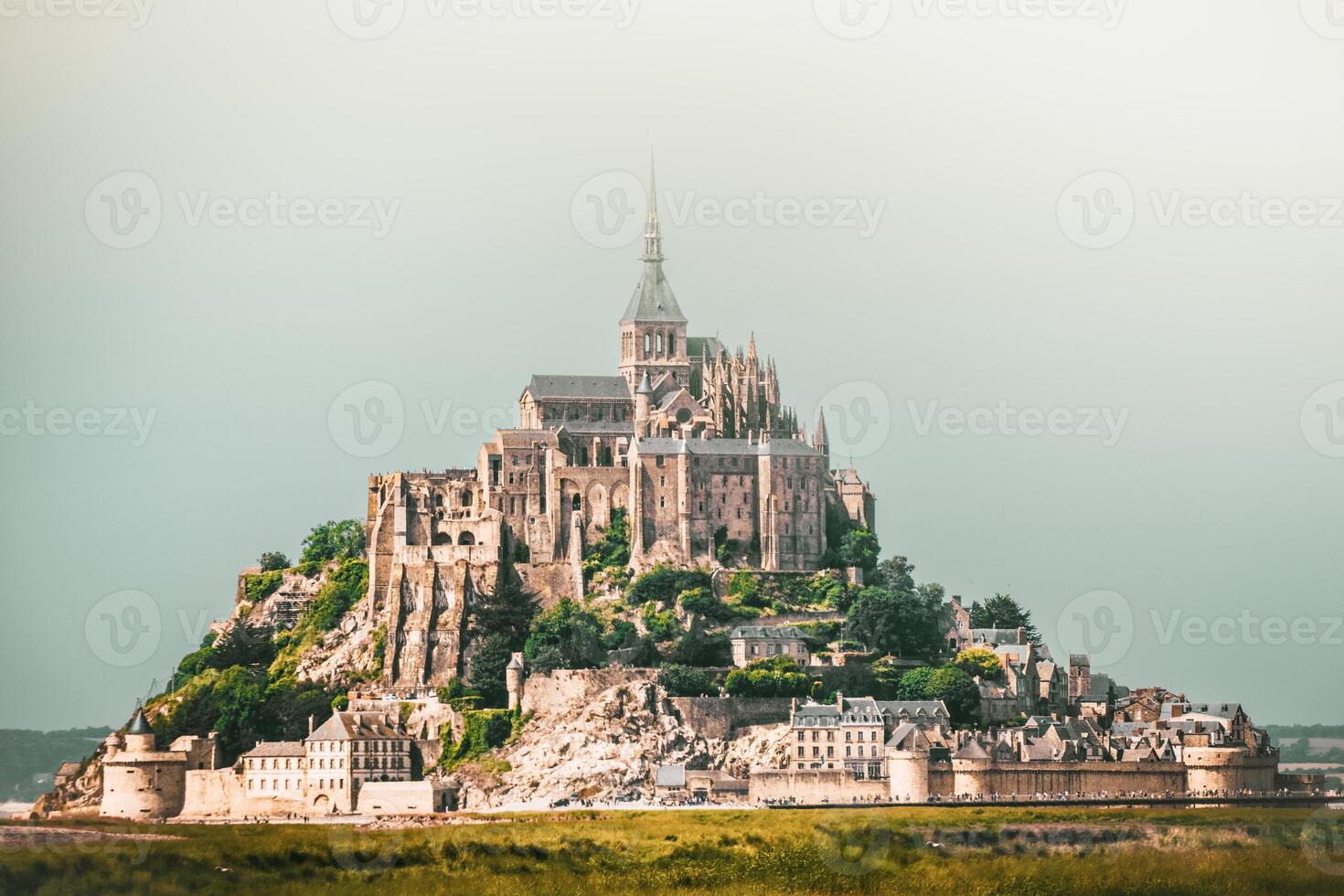 Close up panorama hazy dramatic Mont Saint-Michel, France. Built in the XI-XVI centuries. The main facade of the church built in the 12th century. Architect William de Volpiano photo