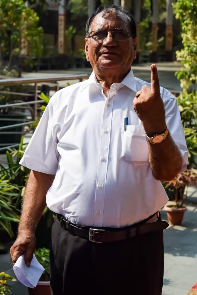 New Delhi, India - May 25 2024 - Unidentified people showing their ink-marked fingers after casting votes in front of polling booth of east Delhi area for general Lok Sabha Elections 2024 photo
