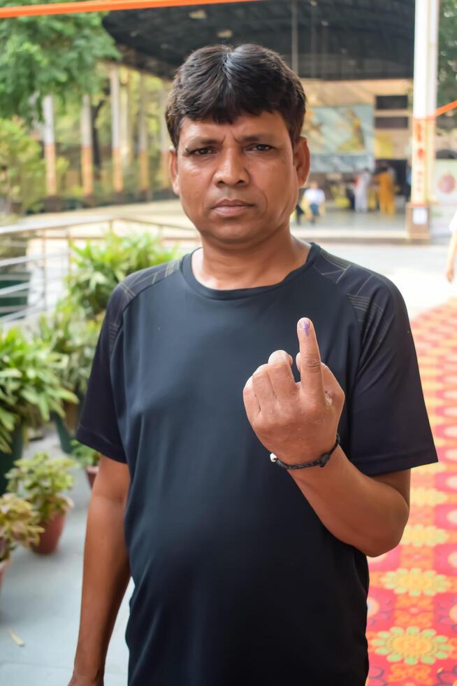 New Delhi, India - May 25 2024 - Unidentified people showing their ink-marked fingers after casting votes in front of polling booth of east Delhi area for general Lok Sabha Elections 2024 photo