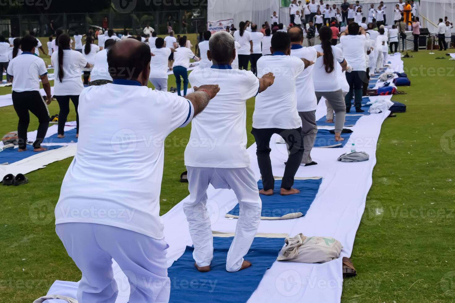 Group Yoga exercise session for people of different age groups at cricket stadium in Delhi on International Yoga Day, Big group of adults attending yoga session photo