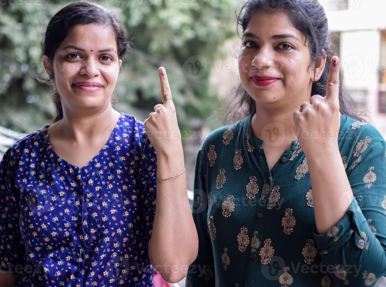 Two Smart young lady showing her ink-marked fingers after casting votes in front of polling booth of east Delhi area for general Lok Sabha Elections 2024 photo