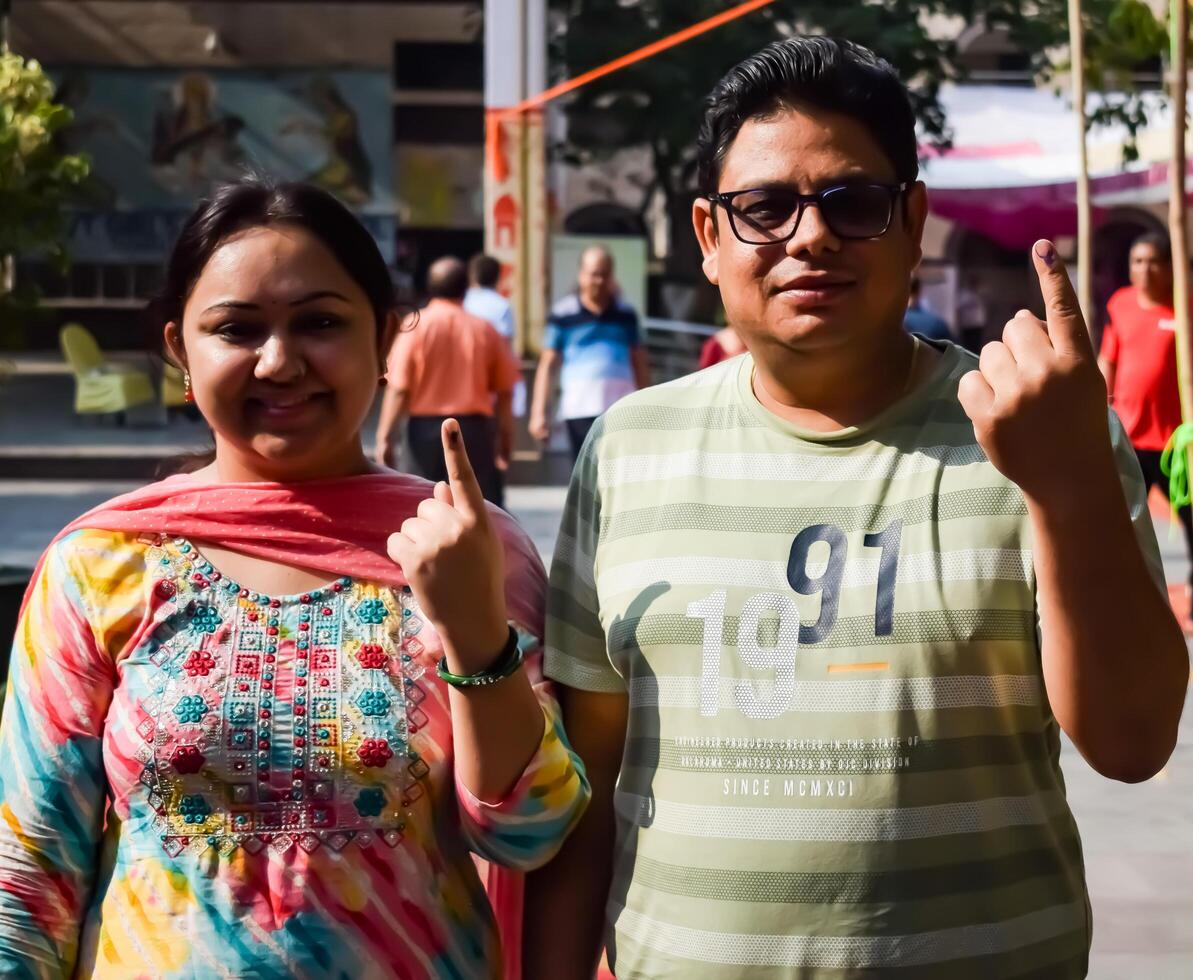 New Delhi, India - May 25 2024 - Unidentified people showing their ink-marked fingers after casting votes in front of polling booth of east Delhi area for general Lok Sabha Elections 2024 photo