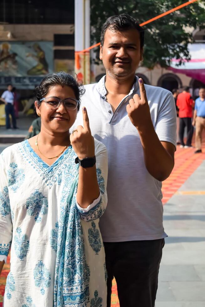 New Delhi, India - May 25 2024 - Unidentified people showing their ink-marked fingers after casting votes in front of polling booth of east Delhi area for general Lok Sabha Elections 2024 photo