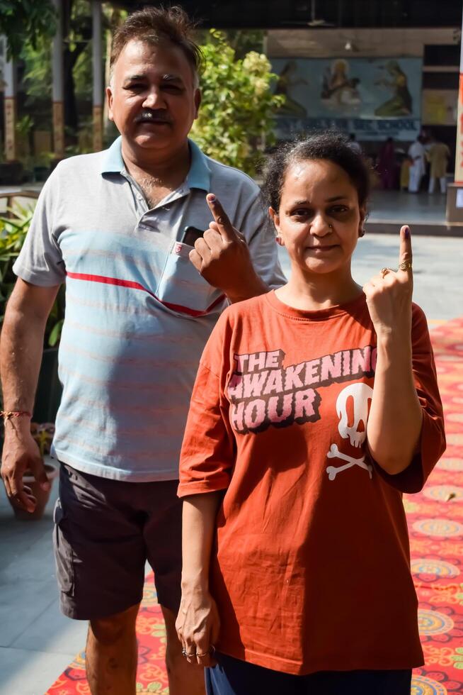 New Delhi, India - May 25 2024 - Unidentified people showing their ink-marked fingers after casting votes in front of polling booth of east Delhi area for general Lok Sabha Elections 2024 photo