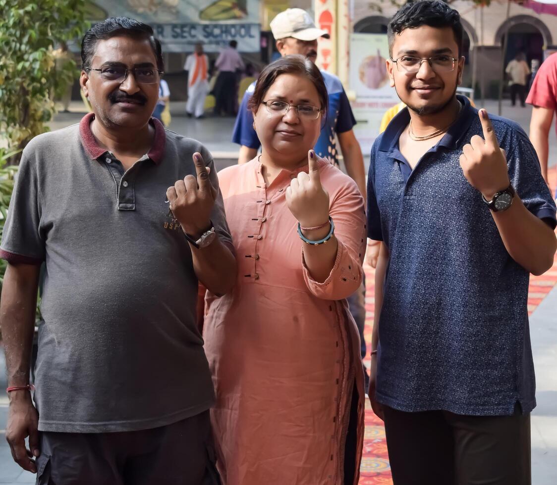 New Delhi, India - May 25 2024 - Unidentified people showing their ink-marked fingers after casting votes in front of polling booth of east Delhi area for general Lok Sabha Elections 2024 photo