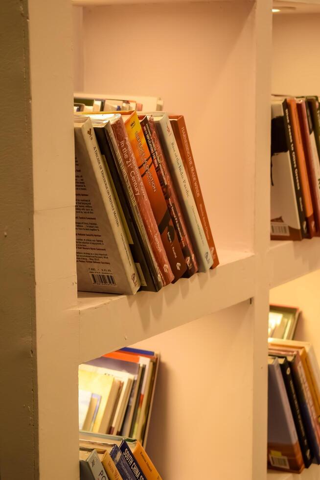 New Delhi, India, May 17 2024 - Variety of Books on shelf inside a book-stall at Delhi International Book Fair, Selection of books on display in Annual Book Fair at Bharat Mandapam complex photo