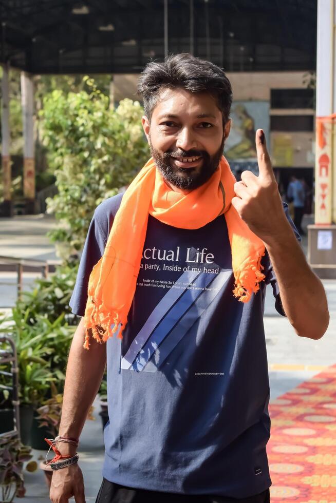 New Delhi, India - May 25 2024 - Unidentified people showing their ink-marked fingers after casting votes in front of polling booth of east Delhi area for general Lok Sabha Elections 2024 photo