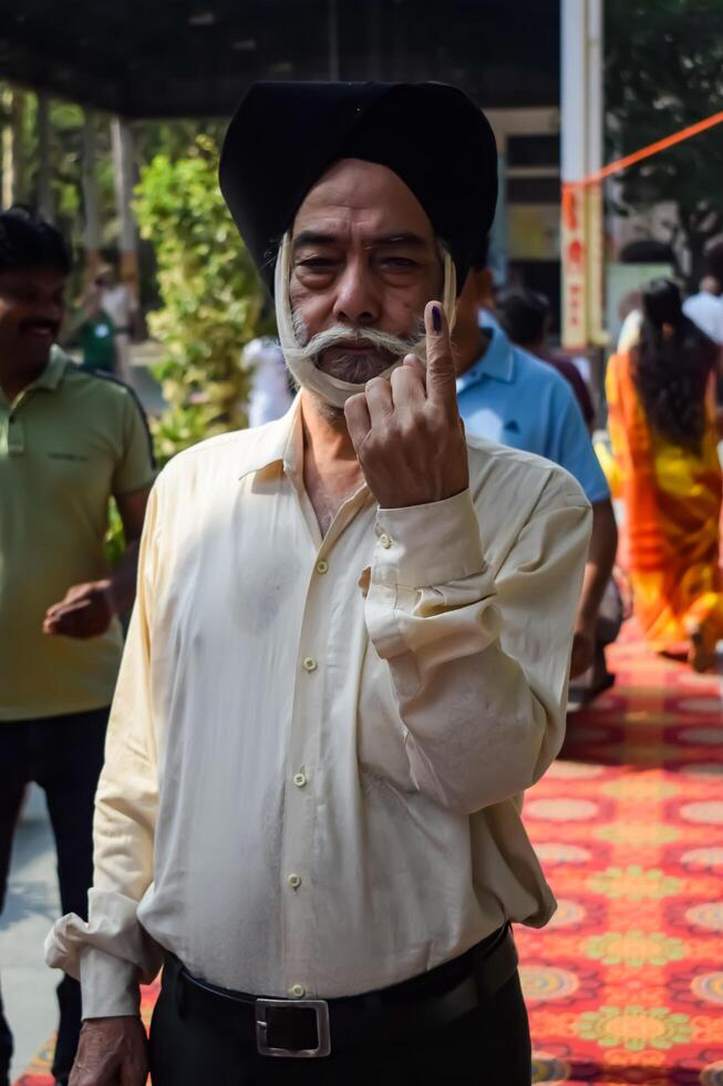 New Delhi, India - May 25 2024 - Unidentified people showing their ink-marked fingers after casting votes in front of polling booth of east Delhi area for general Lok Sabha Elections 2024 photo