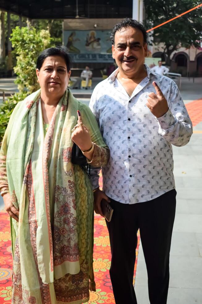 New Delhi, India - May 25 2024 - Unidentified people showing their ink-marked fingers after casting votes in front of polling booth of east Delhi area for general Lok Sabha Elections 2024 photo