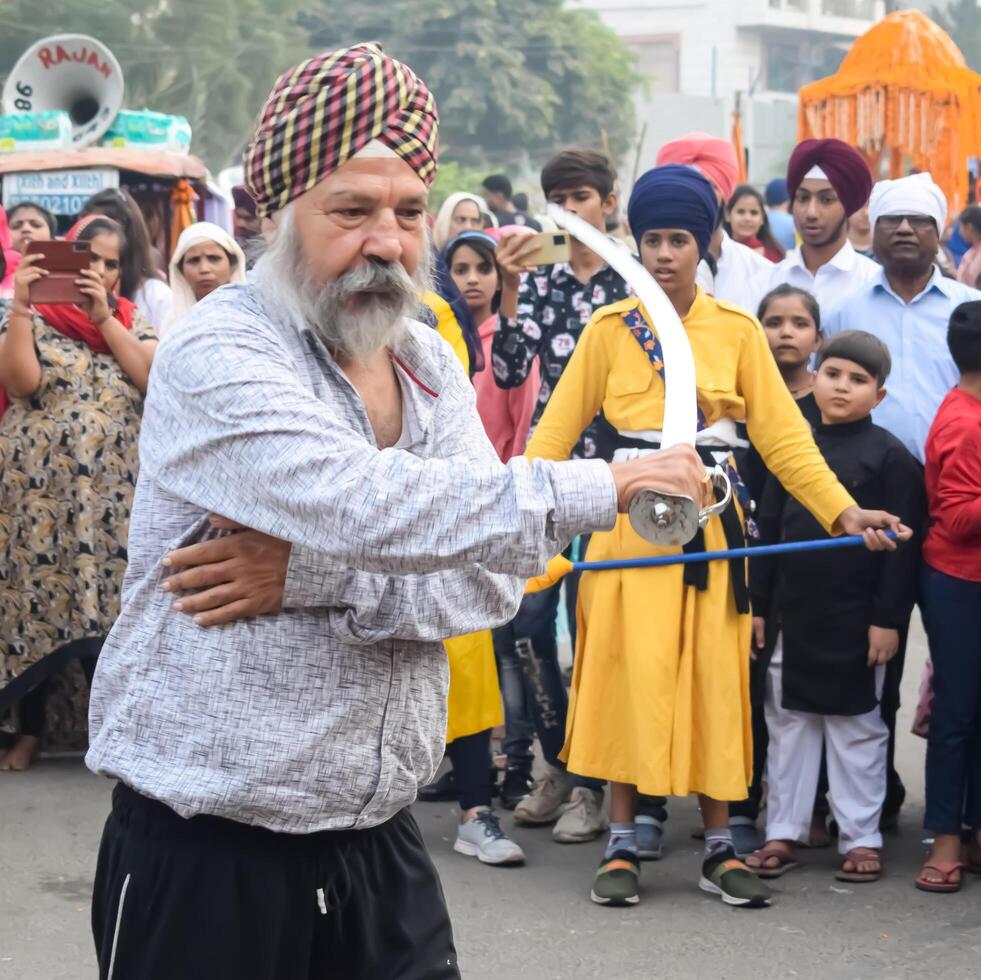 Delhi, India, May 2, 2024 - Sikhs display gatka and martial arts during annual Nagar Kirtan, Traditional, procession on account of birthday of Guru Nanak Dev ji, Nagar Kirtan in East Delhi area photo