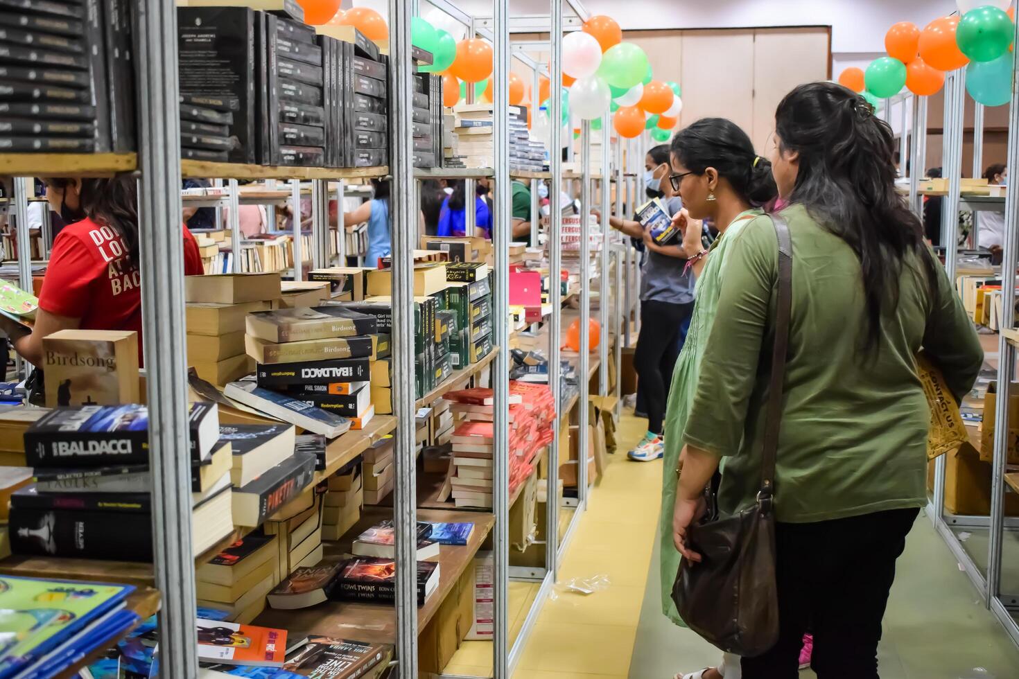 Delhi, India, May 09 2024-Various age group people reading variety of Books on shelf inside a book stall at Delhi photo