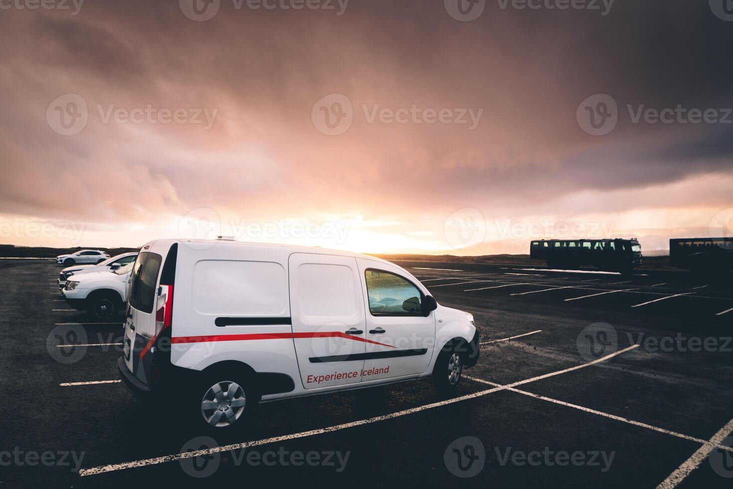 Reykjavik, Iceland , 2023 - white camper van stand in parking lot in Iceland with sunset background photo