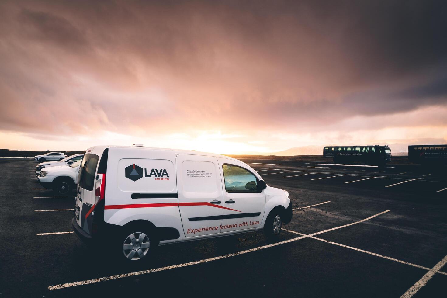 Reykjavik, Iceland, 2023 - famous budget Lava company rented white camper van stand in parking lot in Iceland with sunset background photo