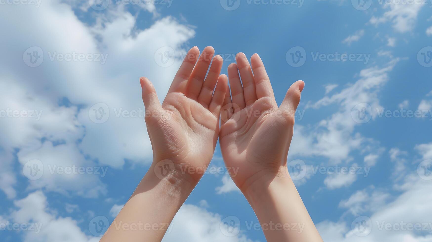 Two hands are raised in the air, with the fingers spread out photo