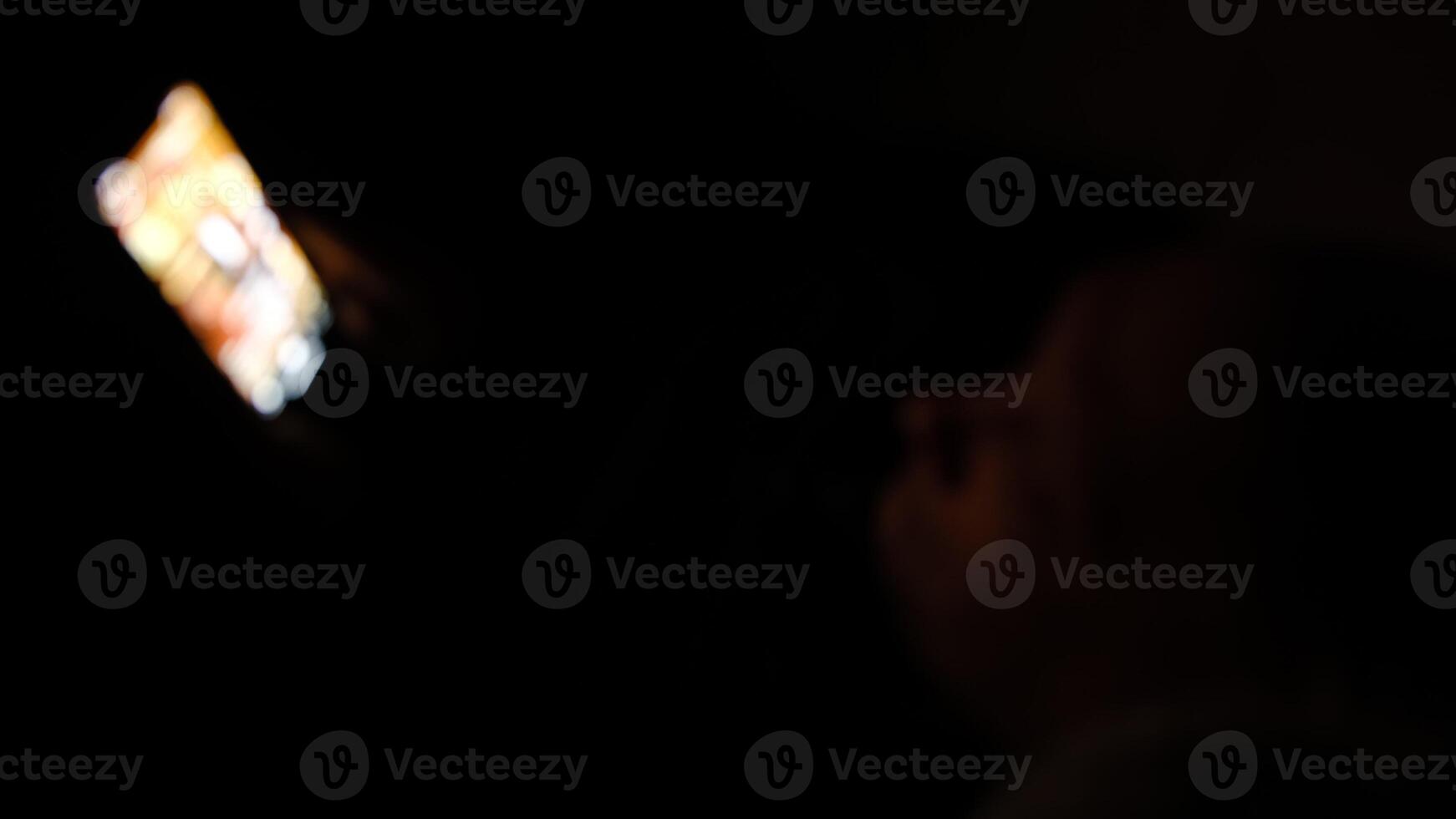 Blured Lonely caucasian middle ages man lie on bed in bedroom and using phone at night. Face illuminated from smartphone display. Surfing social network before sleep photo
