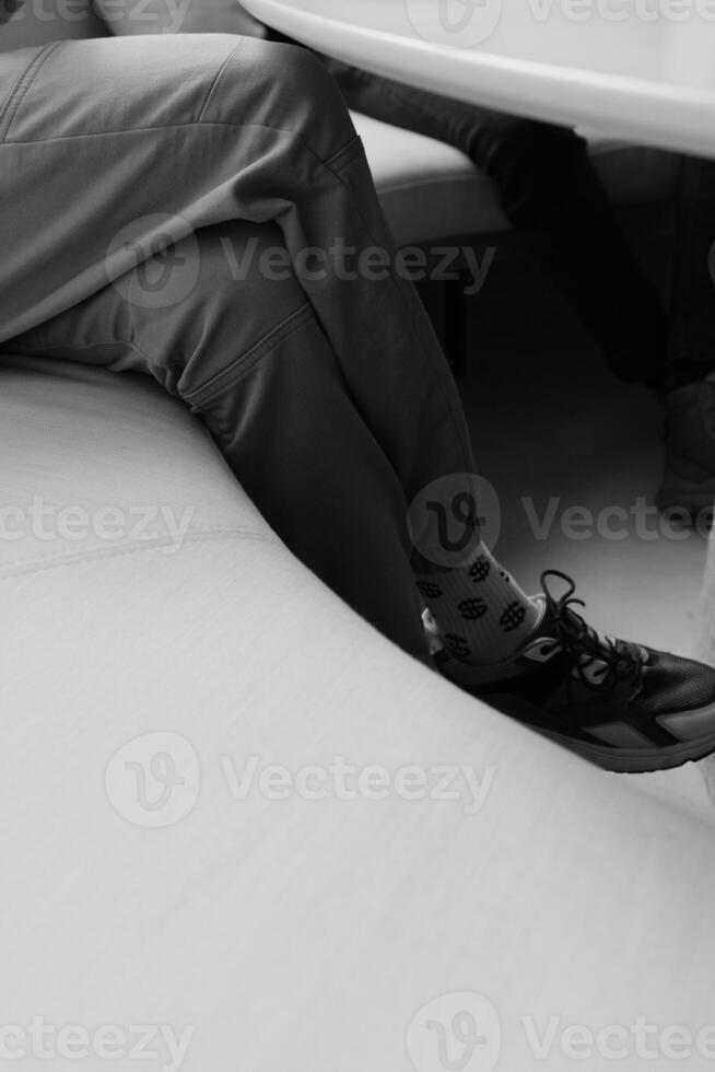 pair of legs in socks with a dollar pattern, black and white photo of the modern man in pants shoes and soks with dollar patern
