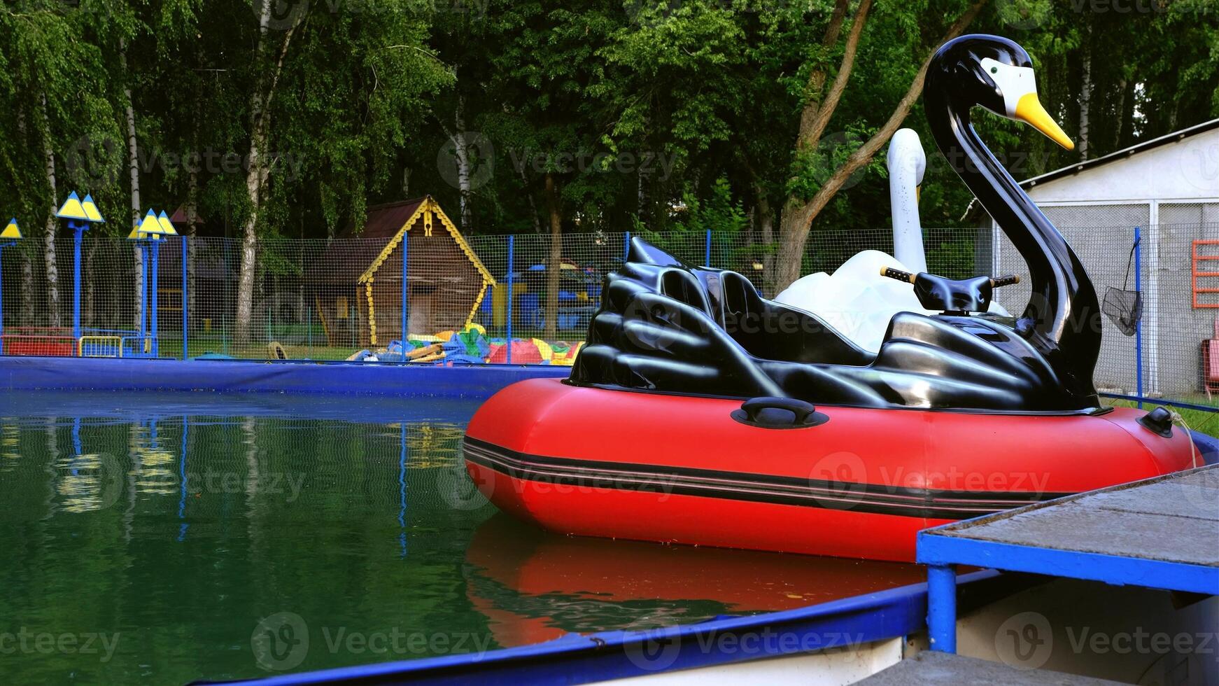 view of inflatable boats in the form of birds swan, pelican on the water in the pool in the spring photo