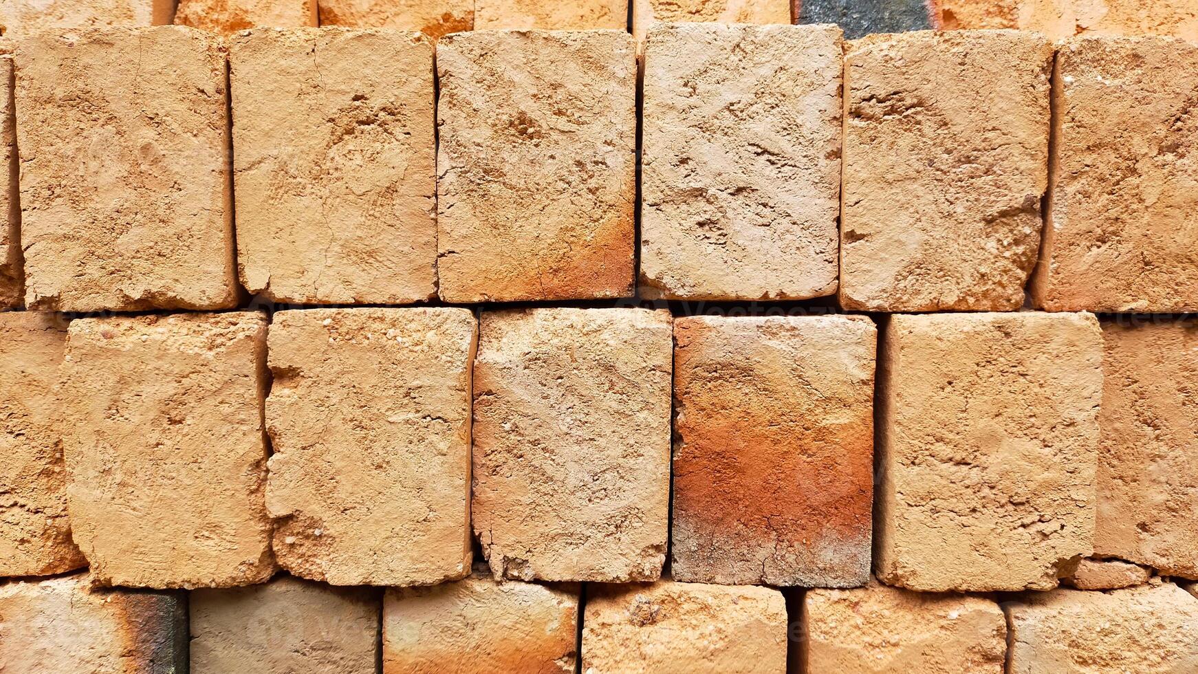 Close up view of stacked red clay bricks with rich textures and warm earthy tones, ideal for construction and architectural projects, showcasing natural building materials in a sunny outdoor setting photo