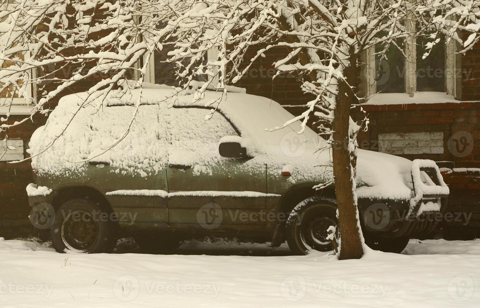 Photo of a car covered in a thick layer of snow. Consequences of heavy snowfall