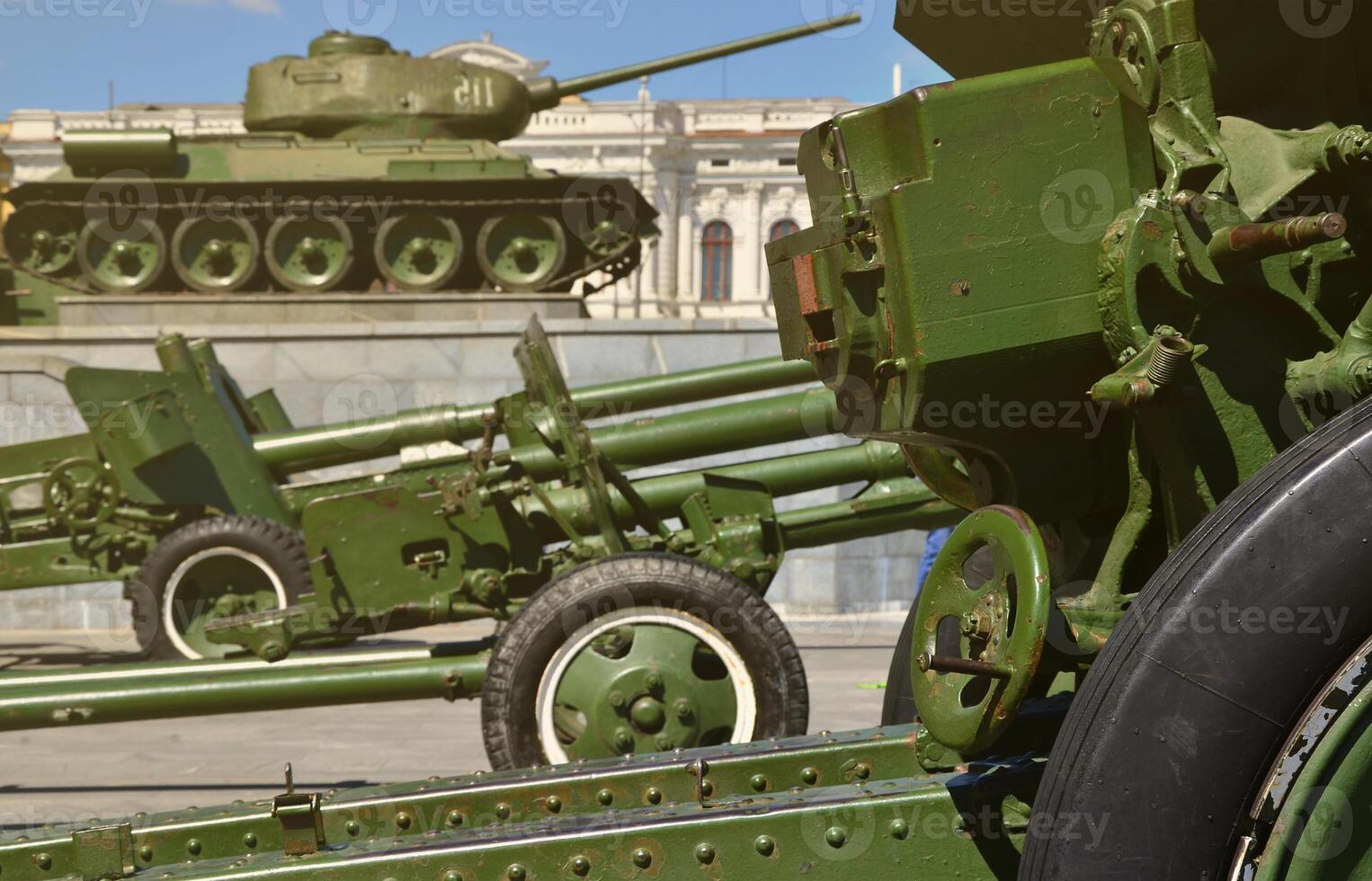 Photo of three guns of the Soviet Union of the Second World War against the background of the green tank T-34