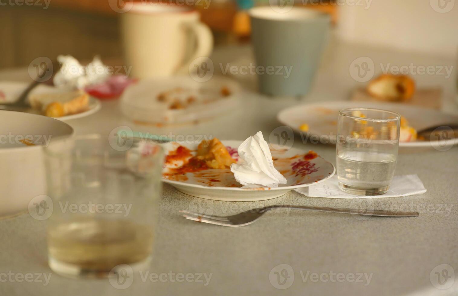 Empty dirty plates with spoons and forks on the table after meal. Banquet ending concept. Unwashed dishes photo