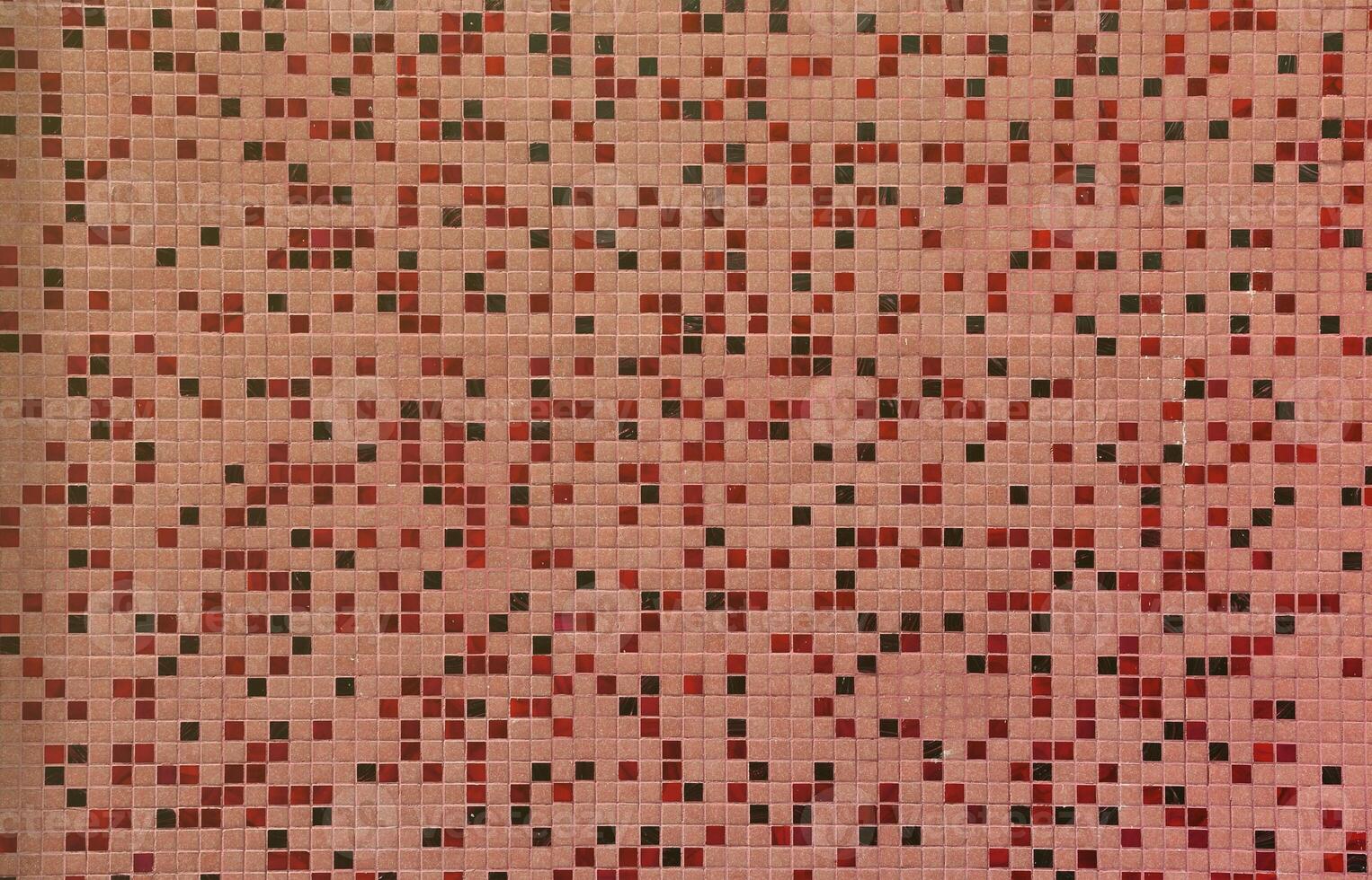 The texture of the wall, decorated with a mosaic of various small square tiles. Abstract pattern of ceramic tiles on the wall photo