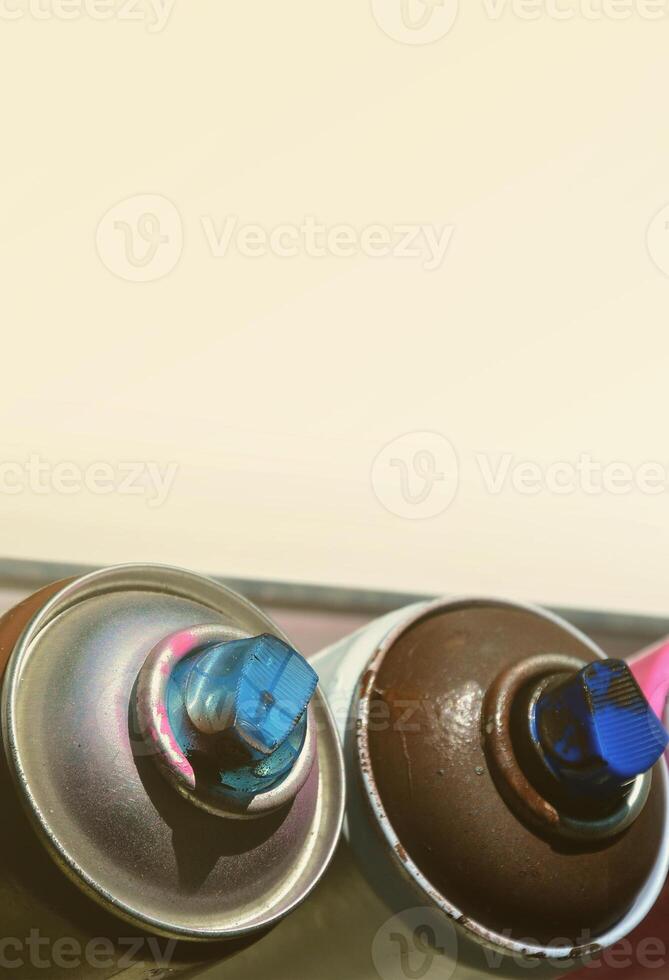 A few used aerosol paint sprayers lie on the windowsill in the workshop of a graffiti artist. The concept of street art and illegal drawing on the walls. Youth hobby photo