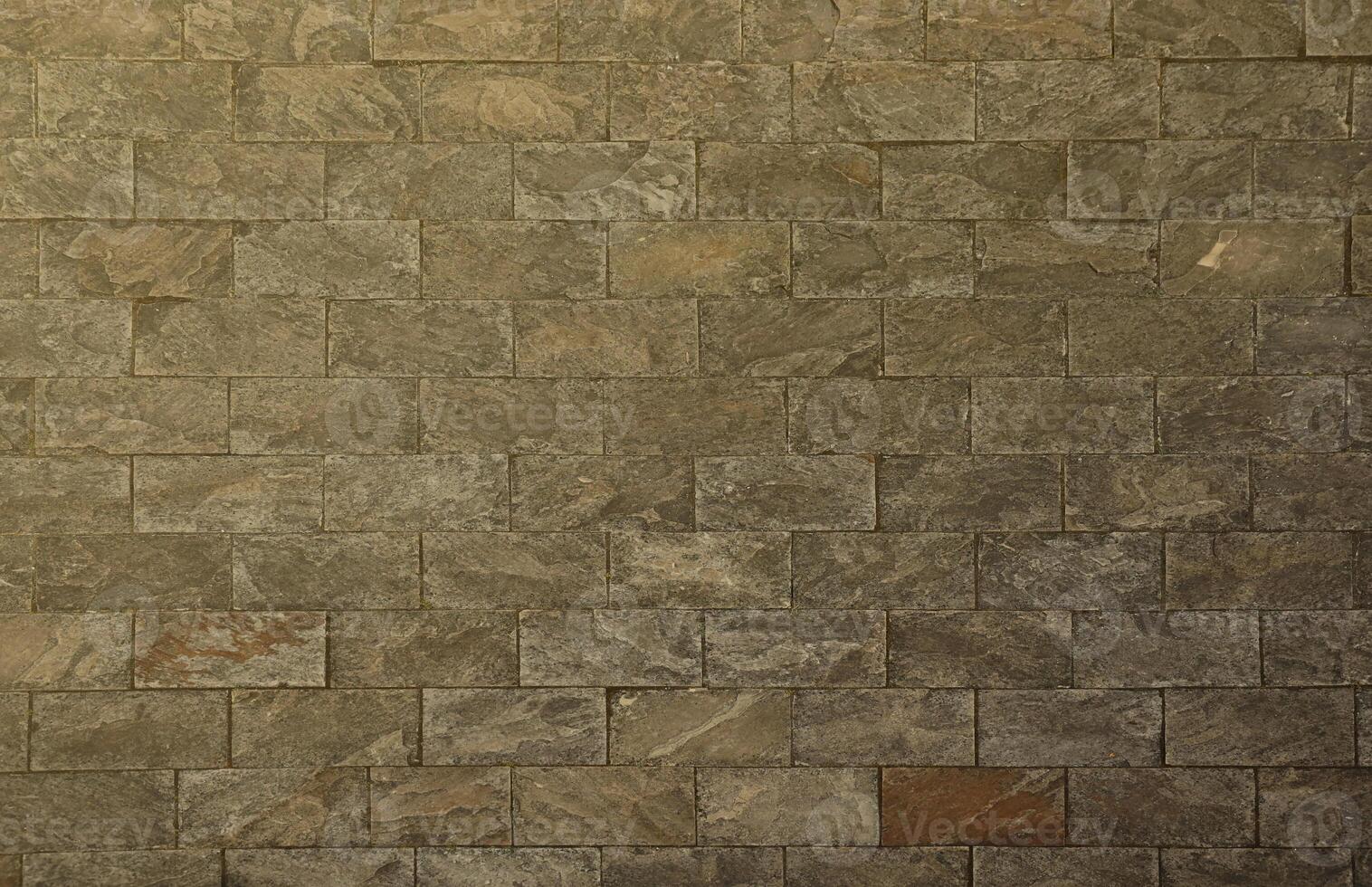 Very old brick stone wall of castle or fortress of 18th century. Full frame wall with obsolete dirty and cracked bricks photo