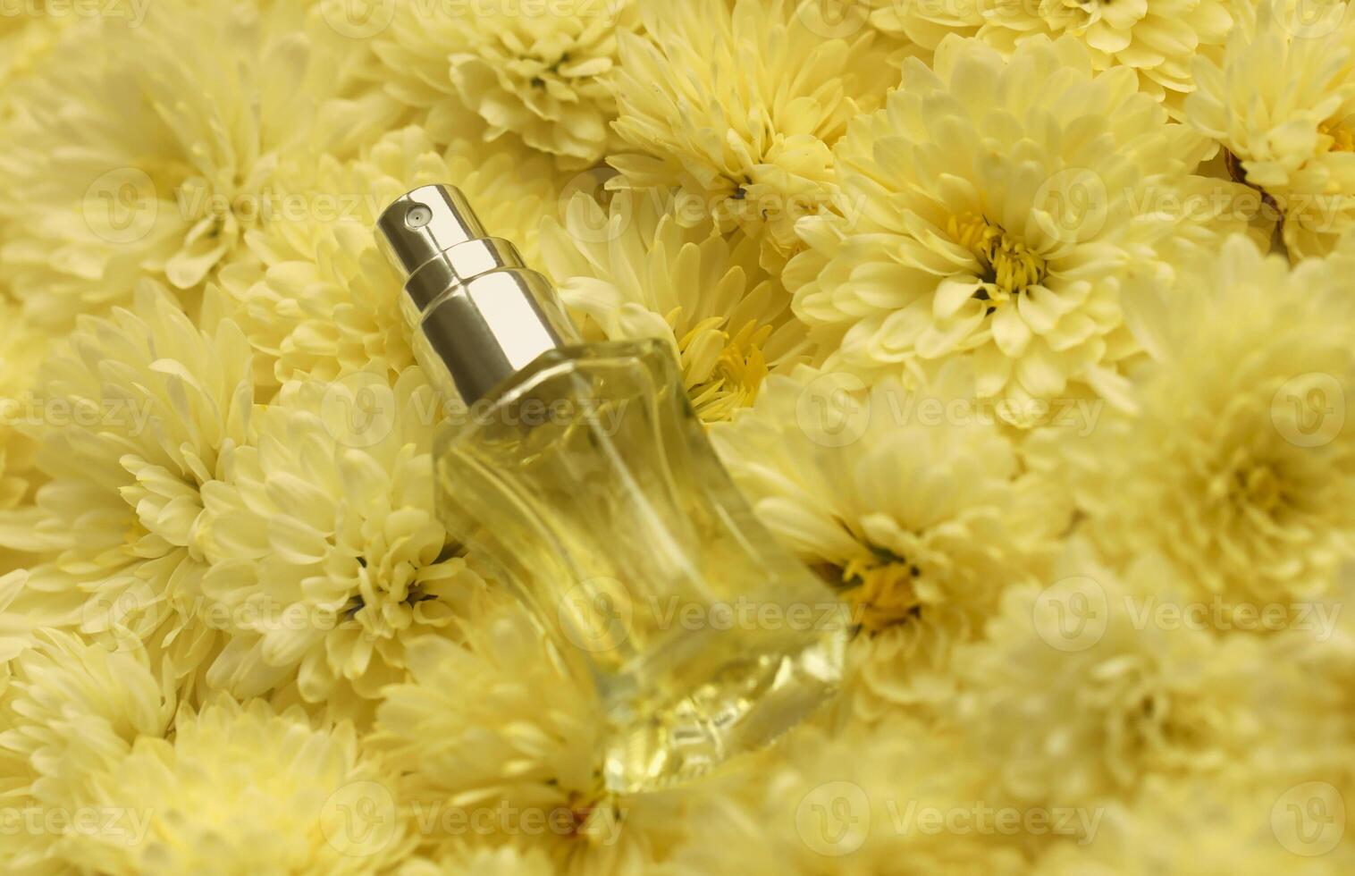Women fragrance perfume bottle with flowers background close up. Unnamed blank sprayer bottle of perfume photo