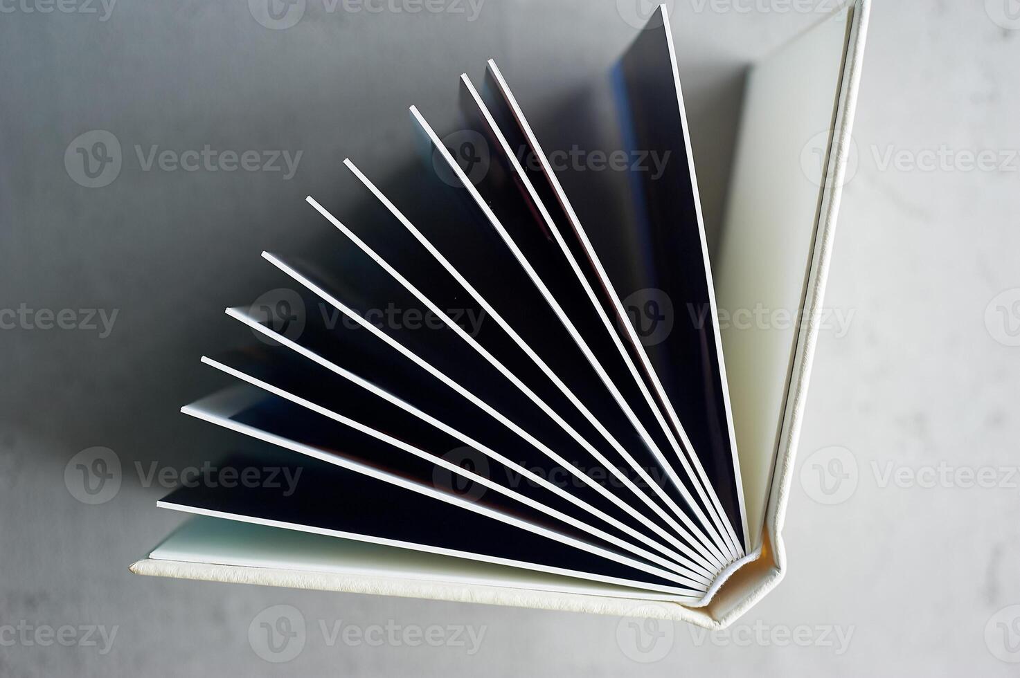 Photobook in hard leather cover on a gray concrete background. Making photos and storing them.A wedding album or book in an expensive binding.