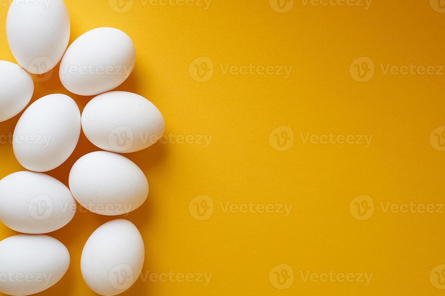Eggs on a yellow background. Smooth beautiful eggs, space for text.Minimalism. The view from the top. photo