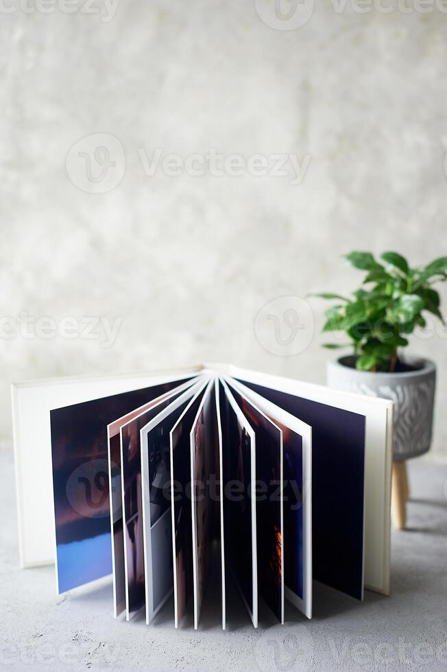 Photobook in hard leather cover on a gray concrete background. Making photos and storing them.A wedding album or book in an expensive binding.