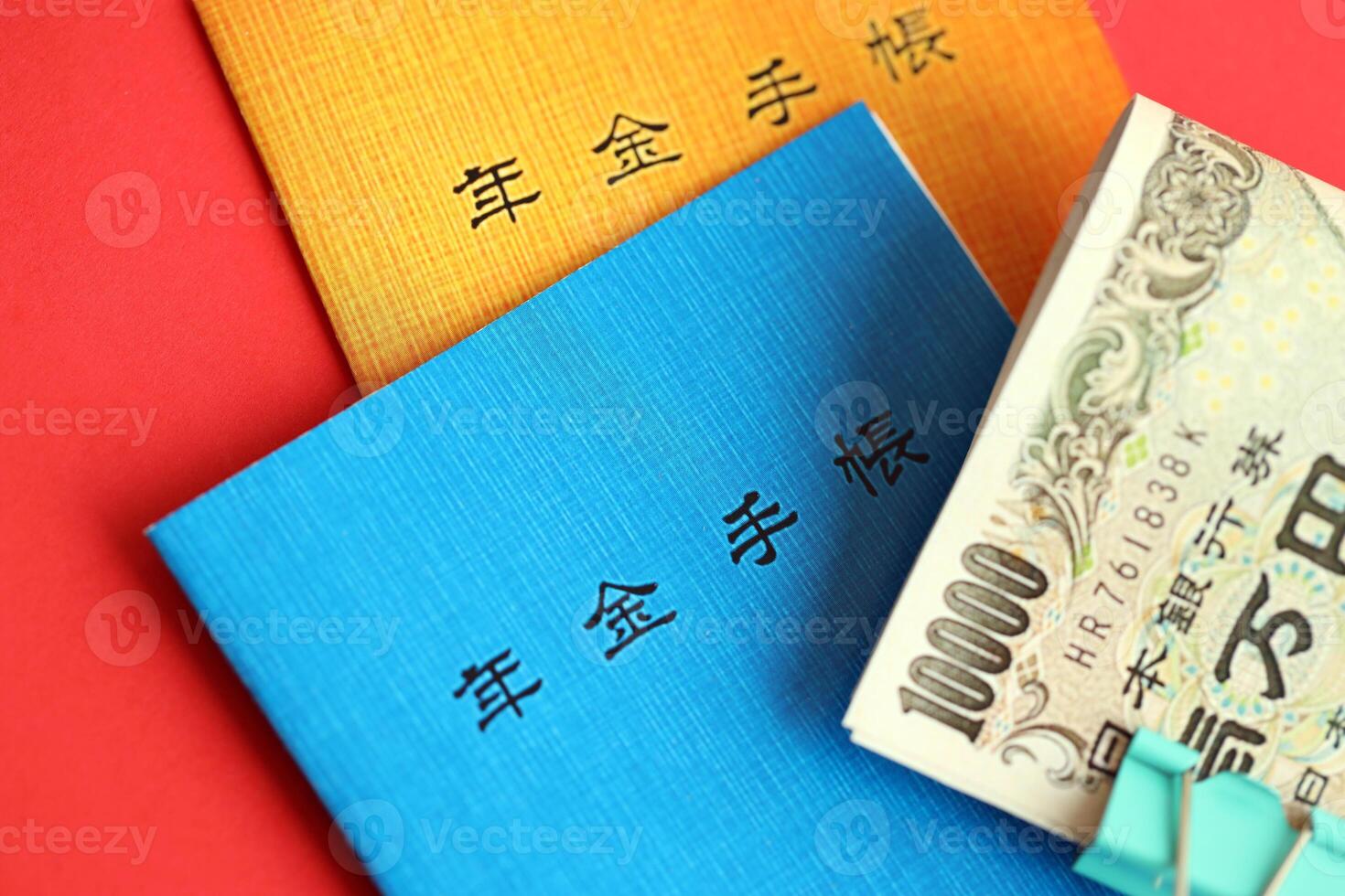 Japanese pension insurance booklets on table with yen money bills. Blue and orange books photo