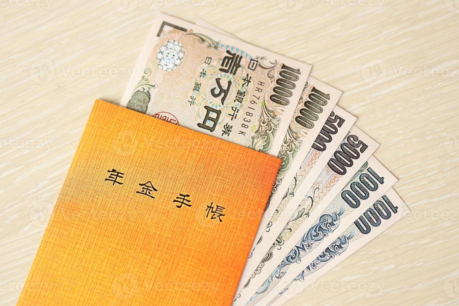 Japanese pension insurance book on table with yen money bills. Orange book for japan pensioners photo