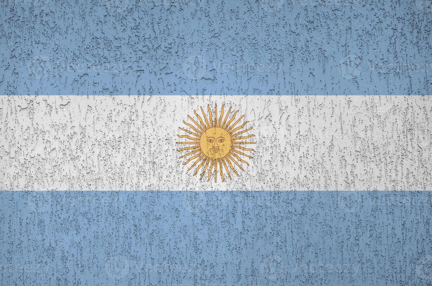 Argentina flag depicted in bright paint colors on old relief plastering wall. Textured banner on rough background photo