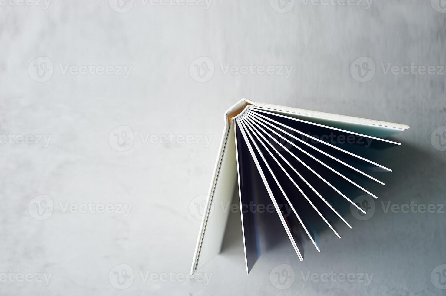 Photobook in hard leather cover on a gray concrete background. Making photos and storing them.A wedding album or book in an expensive binding.