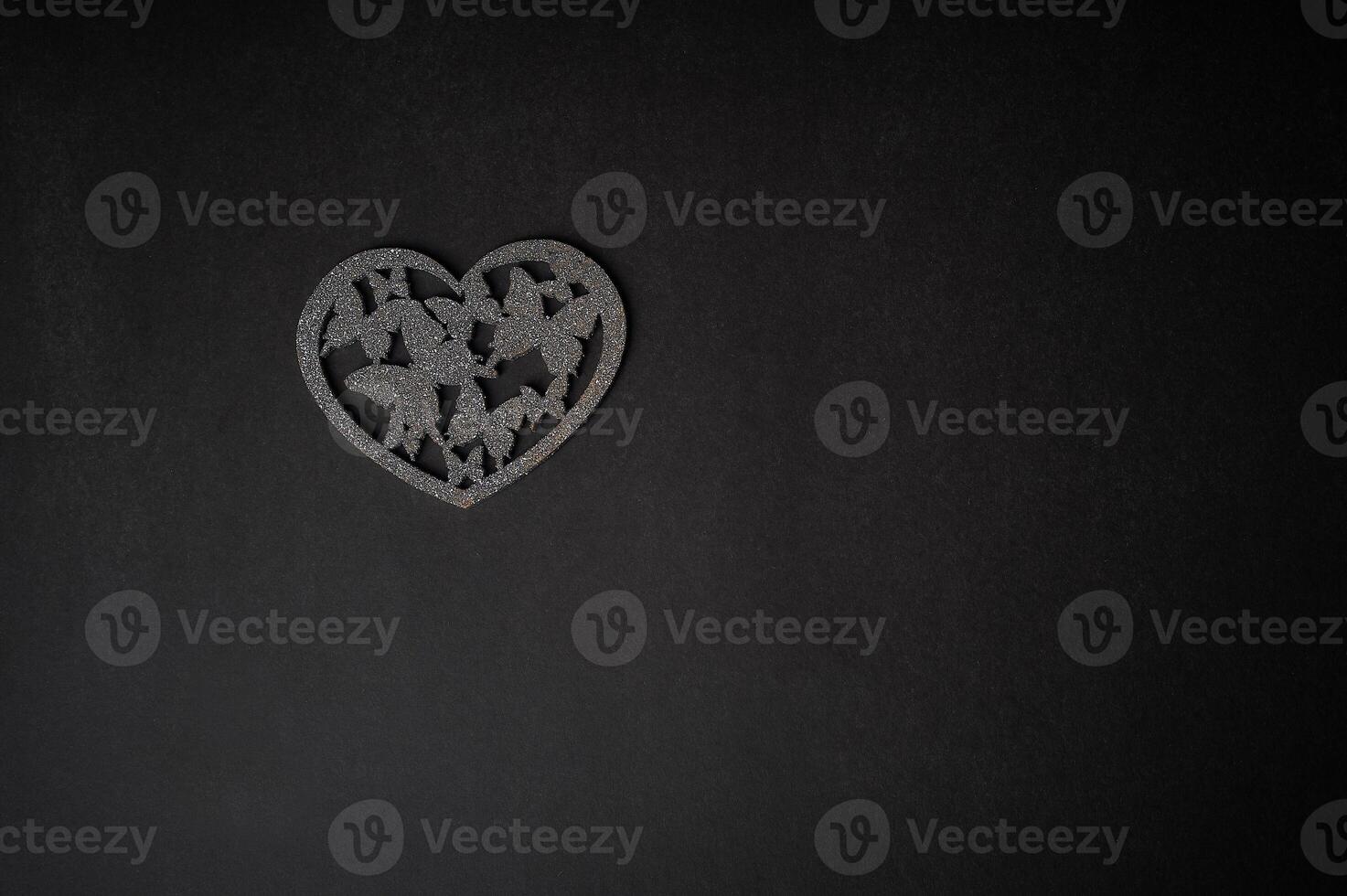 Valentine's day,a Declaration of love. Silver heart with butterflies. Butterflies in the stomach. Silver heart with butterflies on a dark graphite background. photo